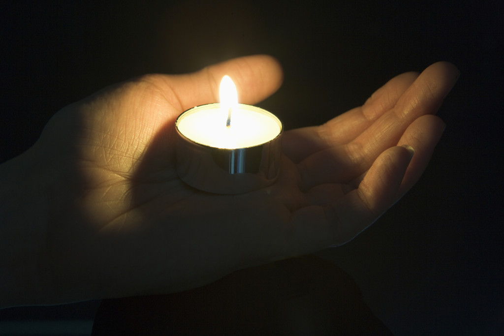 Close-Up Of Candle In The Palm Of A Persons Hand